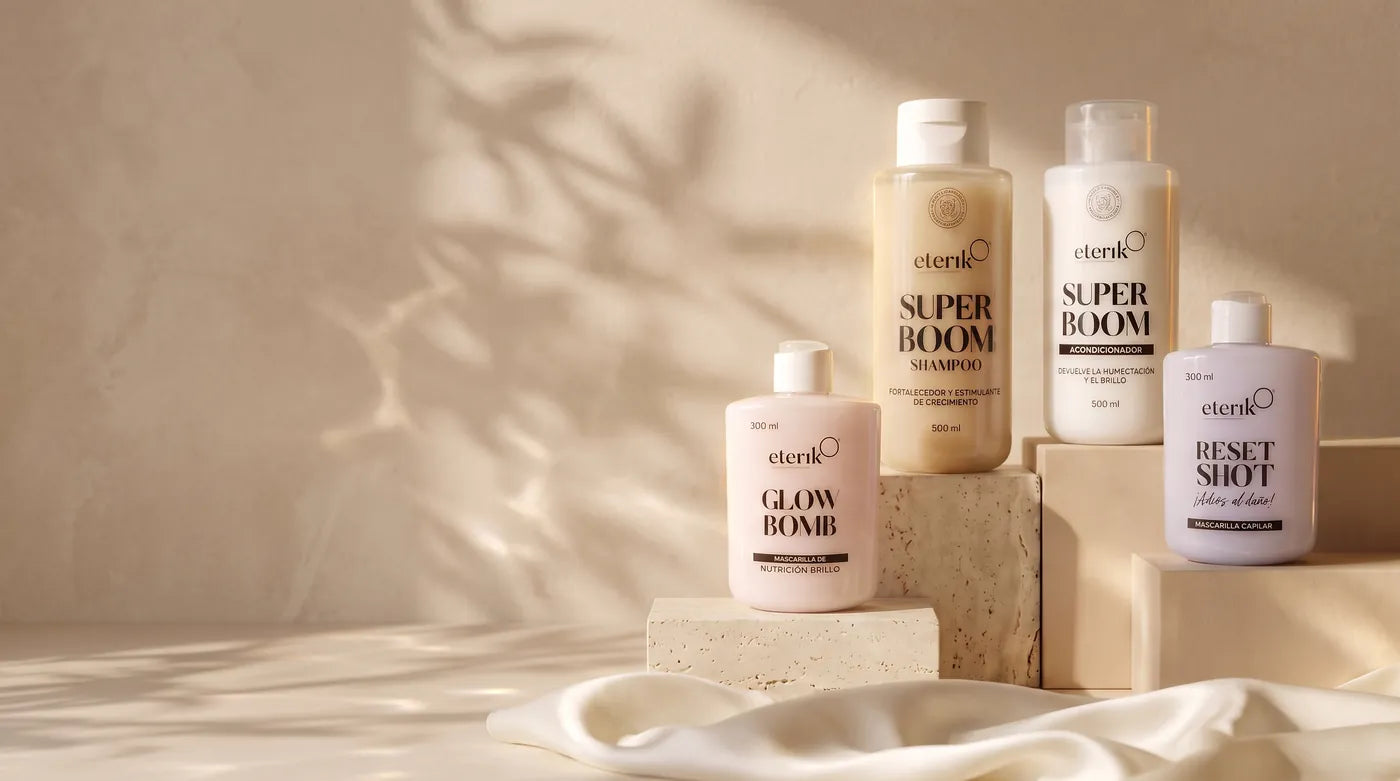 Super Boom Shampoo, Acondicionador, Glow Bomb y Reset Shot de Eterik frente a una pared crema con sombras de hojas