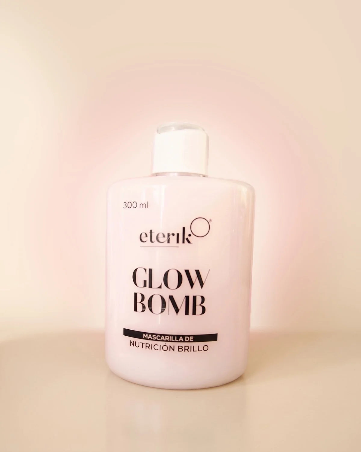 Frasco de Glow Bomb, mascarilla de nutrición brillo de Eterik, 300 ml, color rosa pálido con tapa blanca